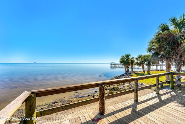 view of dock featuring a beach view and a water view