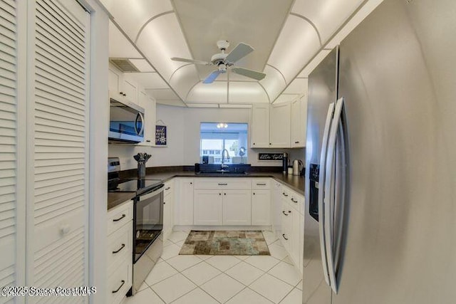 kitchen with ceiling fan, sink, light tile patterned flooring, stainless steel appliances, and white cabinets