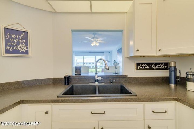 kitchen with ceiling fan, sink, and white cabinetry