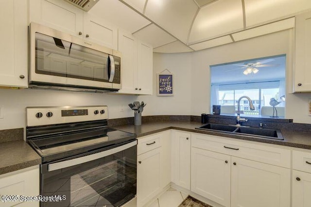 kitchen featuring ceiling fan, tile patterned floors, sink, white cabinetry, and stainless steel appliances