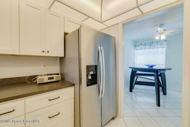 kitchen featuring ceiling fan, light tile patterned floors, stainless steel fridge, and white cabinets