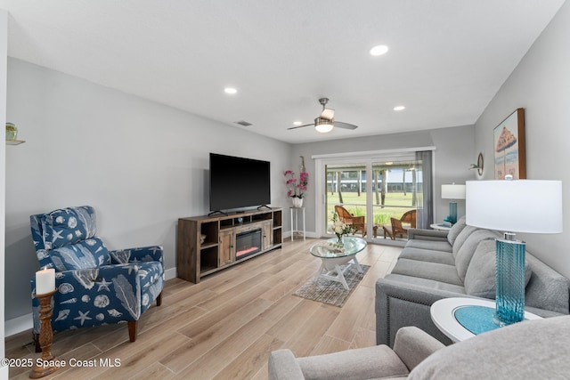 living room with ceiling fan and light hardwood / wood-style flooring