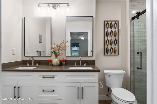 bathroom with toilet, a shower with shower door, and vanity