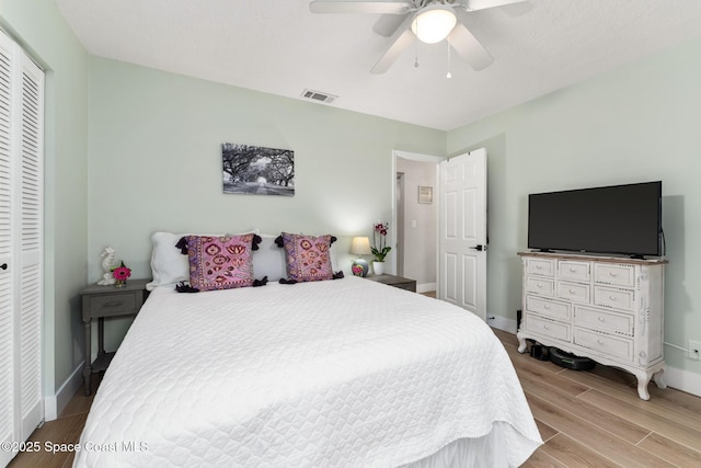 bedroom featuring a closet, light hardwood / wood-style flooring, and ceiling fan