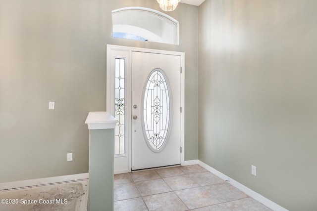 tiled foyer entrance with a notable chandelier