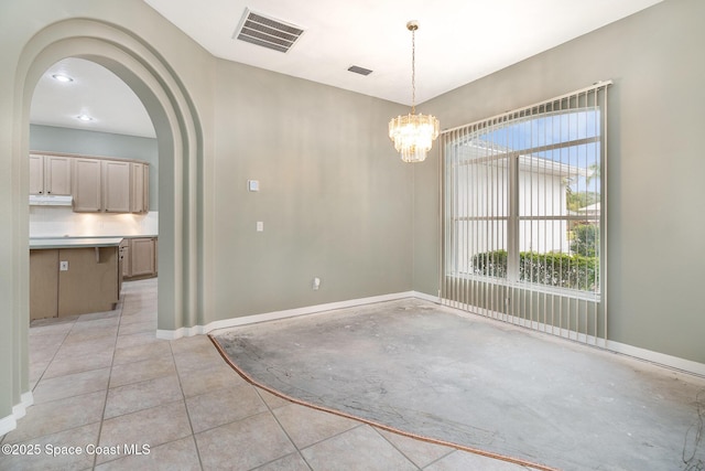 spare room with a notable chandelier