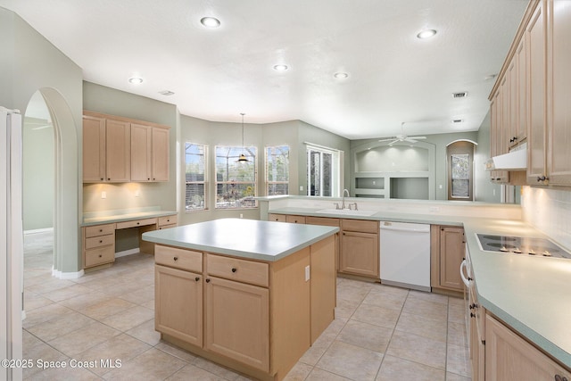 kitchen featuring ceiling fan, decorative light fixtures, a kitchen island, sink, and white dishwasher