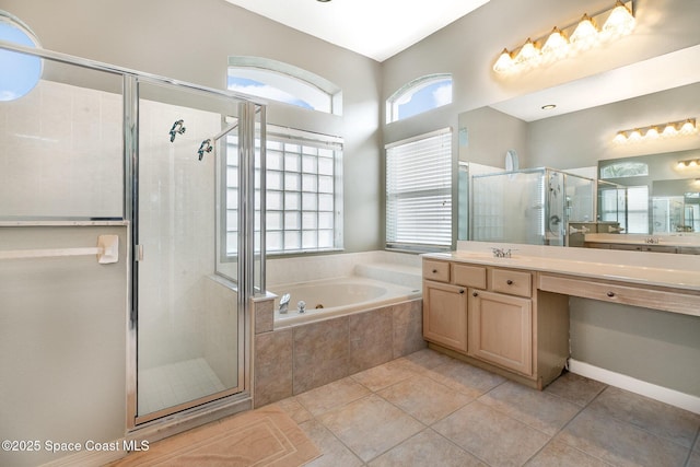 bathroom with vanity, tile patterned flooring, and plus walk in shower