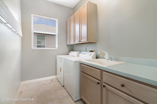 laundry room featuring light tile patterned floors, cabinets, washer and dryer, and sink