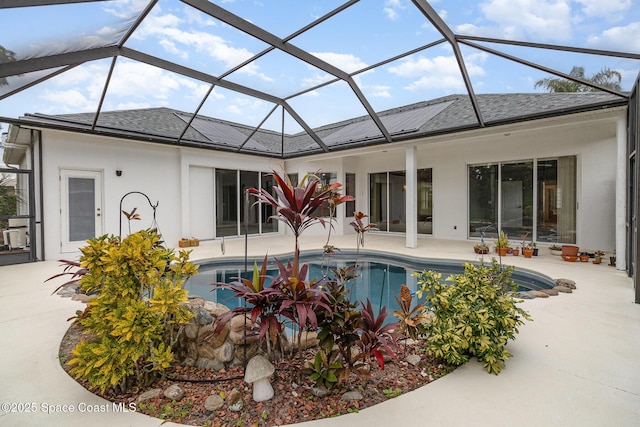 view of swimming pool featuring glass enclosure and a patio