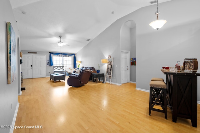 living room featuring ceiling fan, lofted ceiling, and light wood-type flooring