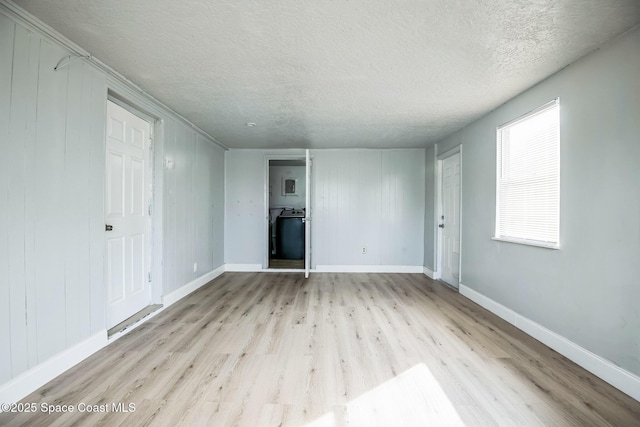 unfurnished living room featuring a textured ceiling and light hardwood / wood-style flooring