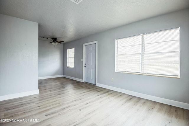 interior space with a textured ceiling, ceiling fan, and light hardwood / wood-style flooring