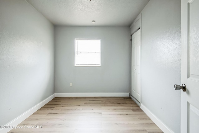 unfurnished bedroom with a textured ceiling and light hardwood / wood-style flooring