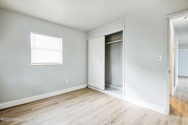 unfurnished bedroom featuring light hardwood / wood-style floors and a closet