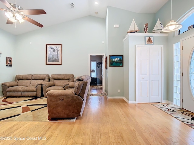 living room with ceiling fan, high vaulted ceiling, and light wood-type flooring