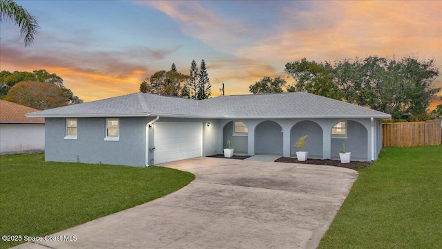 ranch-style house with a garage and a lawn