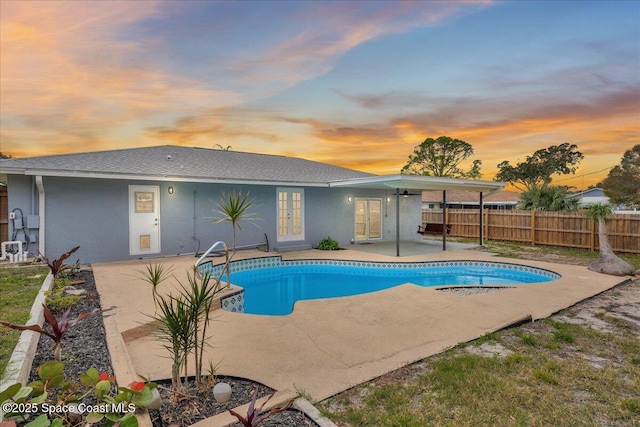 pool at dusk with a patio