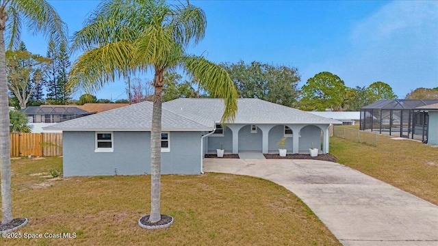 single story home with glass enclosure and a front yard