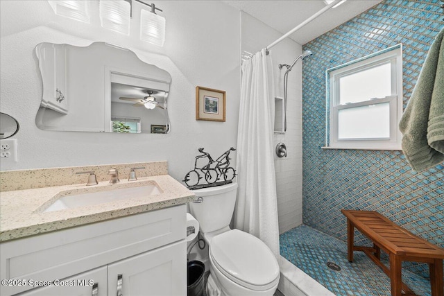 bathroom with walk in shower, ceiling fan, vanity, and toilet