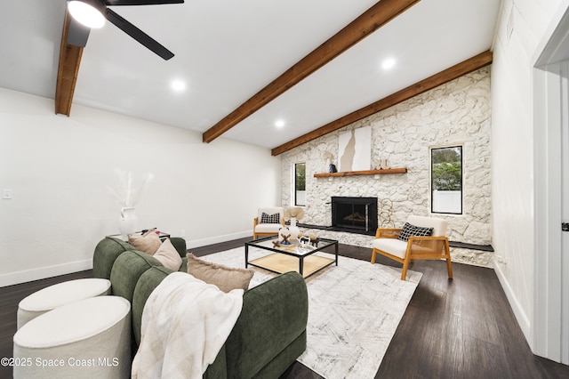 living room with ceiling fan, dark hardwood / wood-style floors, beam ceiling, and a stone fireplace