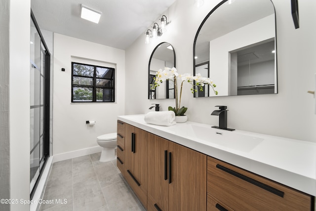 bathroom featuring a shower with shower door, toilet, and vanity