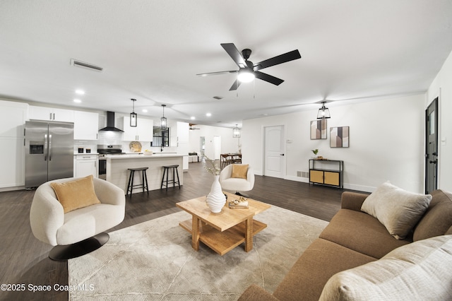 living room with ceiling fan and dark hardwood / wood-style flooring