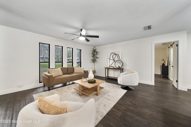 living room with ceiling fan, a textured ceiling, and dark hardwood / wood-style flooring