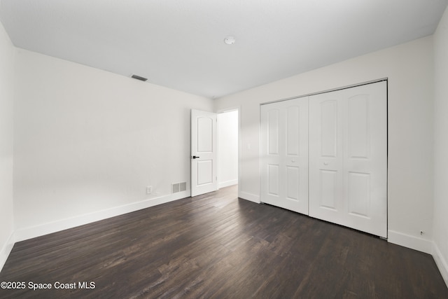 unfurnished bedroom featuring a closet and dark hardwood / wood-style floors