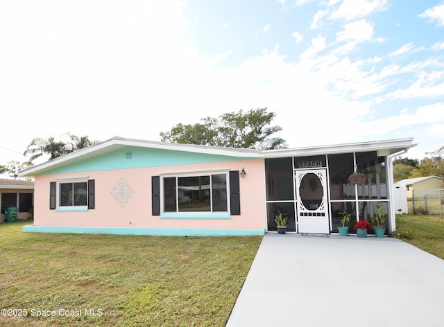 view of front facade with a front lawn and a sunroom