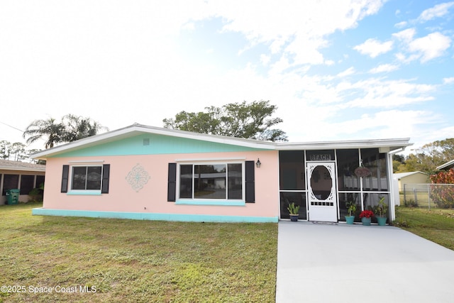 view of front of home with a front lawn and a sunroom