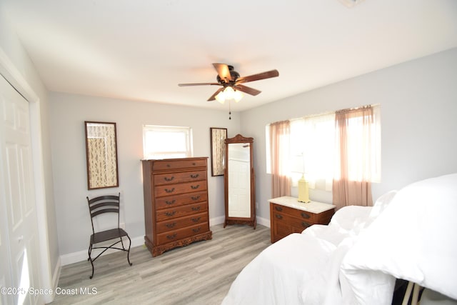 bedroom featuring ceiling fan, a closet, and light wood-type flooring