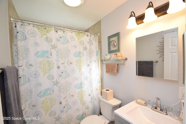 bathroom featuring toilet, a shower with shower curtain, and vanity