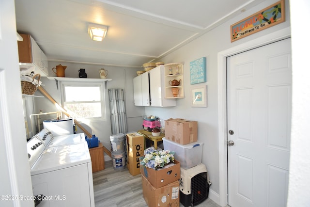 clothes washing area featuring light hardwood / wood-style flooring and washing machine and dryer