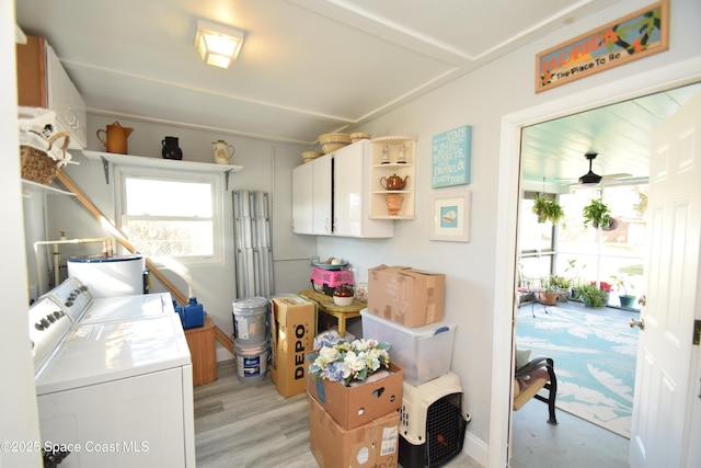 laundry area featuring separate washer and dryer, water heater, cabinets, light wood-type flooring, and ceiling fan