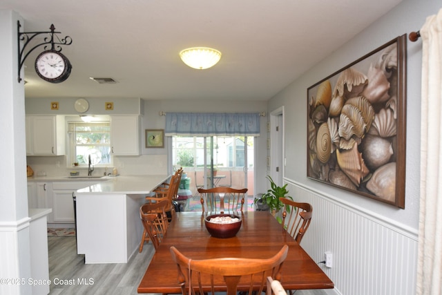 dining space with light wood-type flooring and sink