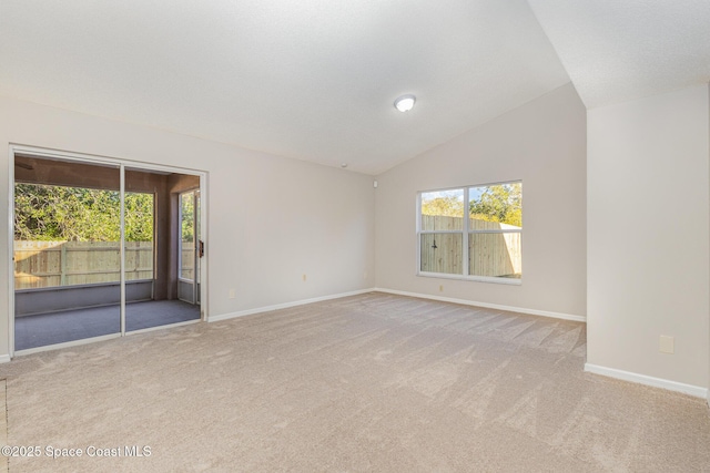 carpeted spare room with lofted ceiling