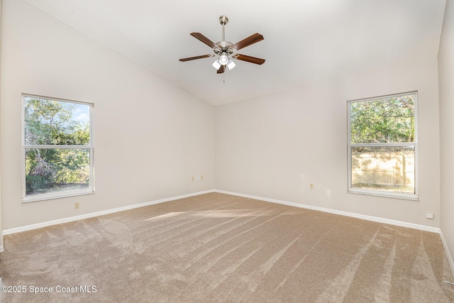 carpeted empty room with ceiling fan, plenty of natural light, and high vaulted ceiling