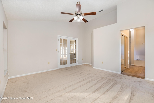 carpeted spare room with a textured ceiling, ceiling fan, french doors, and high vaulted ceiling