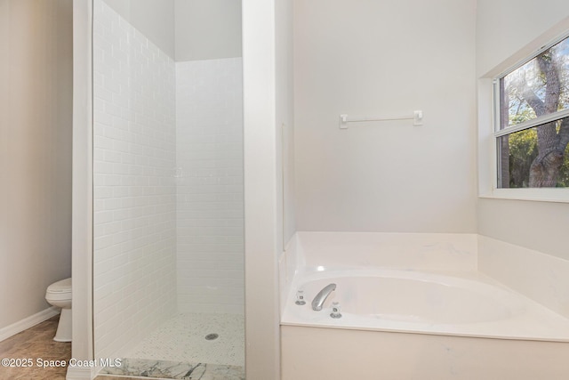 bathroom featuring toilet and separate shower and tub