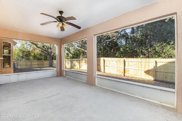 unfurnished sunroom with ceiling fan