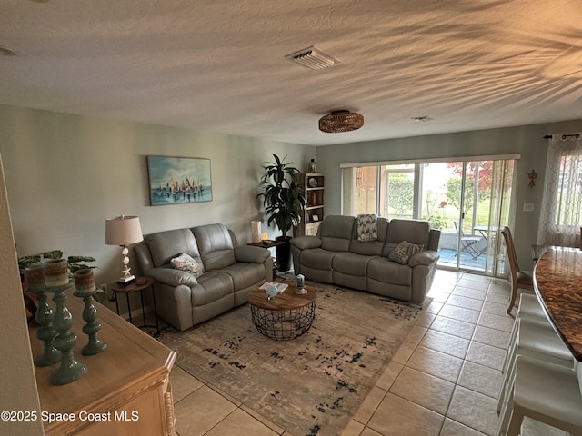 living room featuring a textured ceiling and light tile patterned flooring