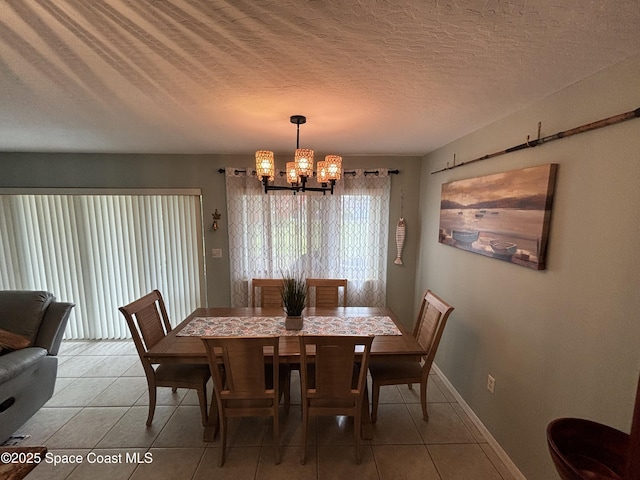 dining space with tile patterned floors, a textured ceiling, and a chandelier