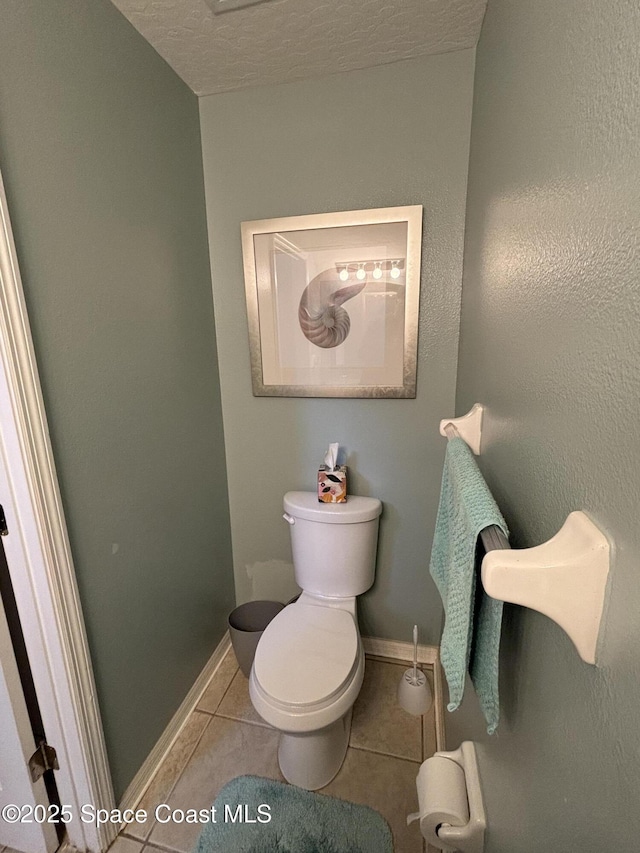 bathroom featuring tile patterned floors, toilet, and a textured ceiling