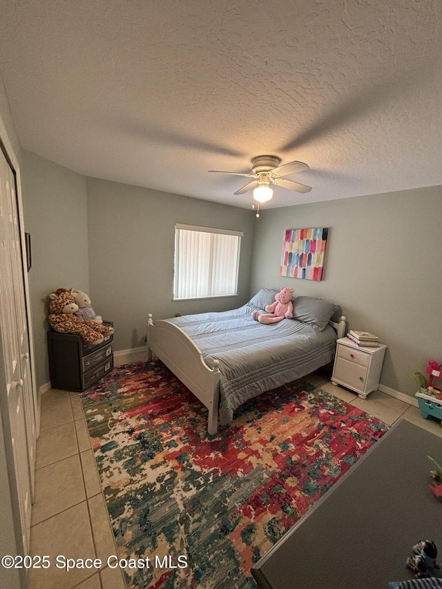 bedroom with tile patterned flooring, a textured ceiling, and ceiling fan