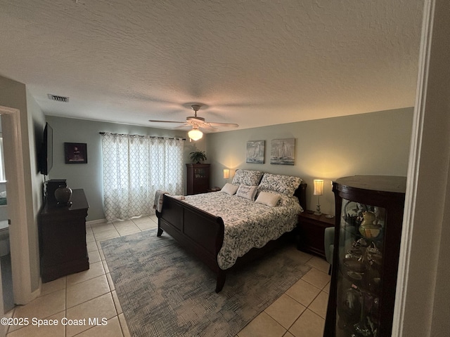 bedroom with light tile patterned flooring, a textured ceiling, and ceiling fan