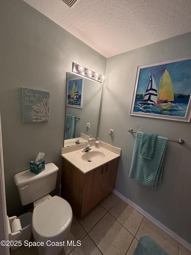 bathroom featuring vanity, toilet, tile patterned flooring, and a textured ceiling