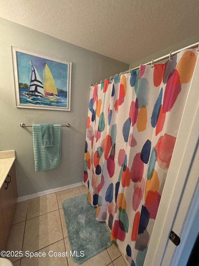 bathroom featuring walk in shower, tile patterned floors, a textured ceiling, and vanity