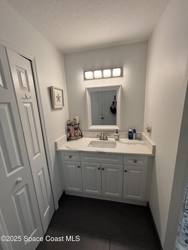 bathroom featuring vanity, tile patterned flooring, and a textured ceiling