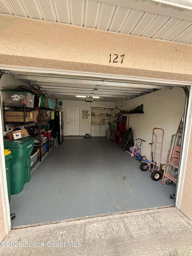 garage featuring a garage door opener and stainless steel refrigerator with ice dispenser